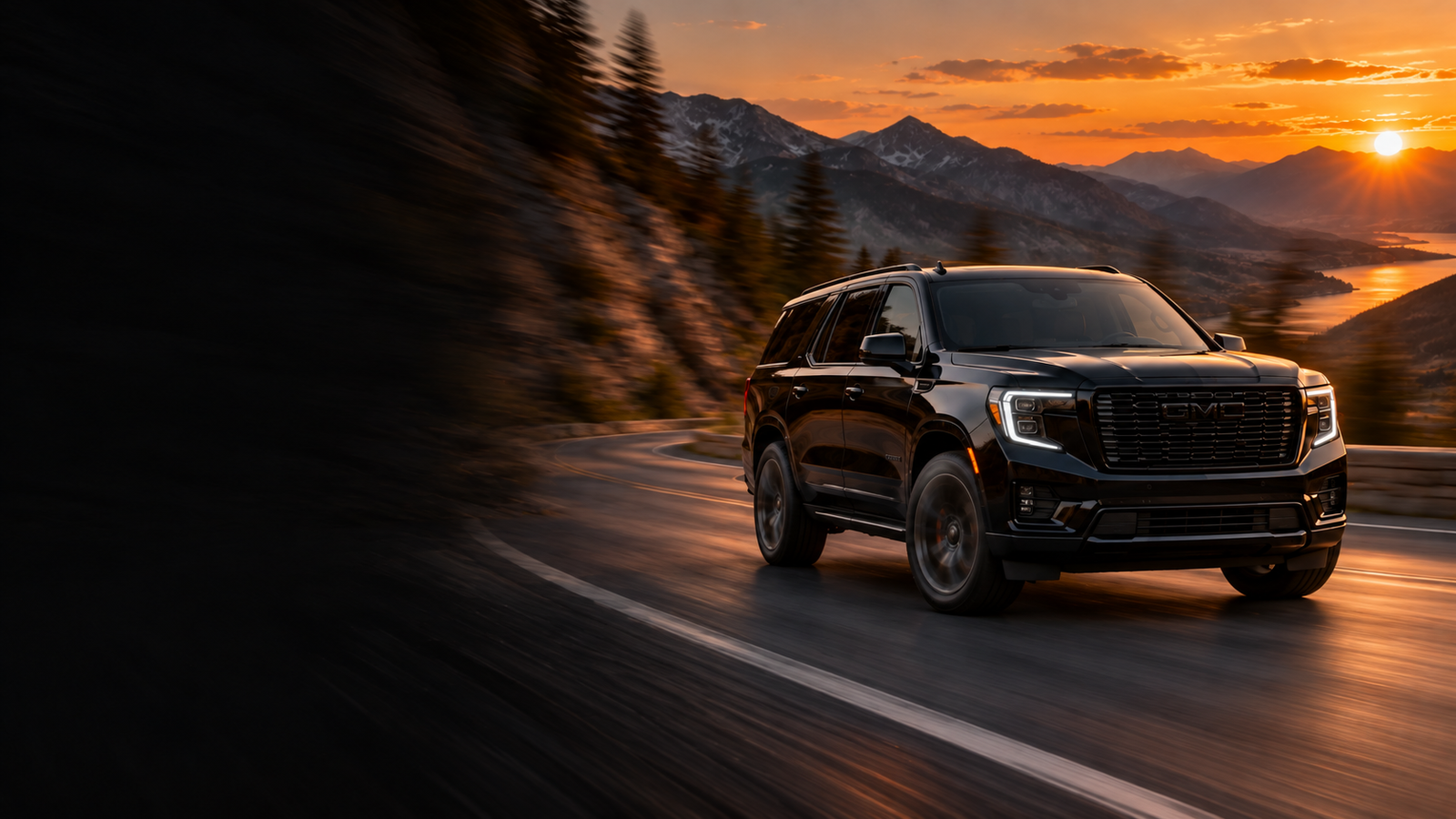 SUV preto com pneus Denali em estrada ao pôr do sol